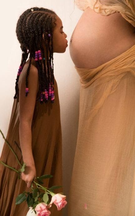 Beyoncé’s first-born daughter, Blue Ivy, poses kissing her mother’s baby bump to show her love for her unborn siblings. 