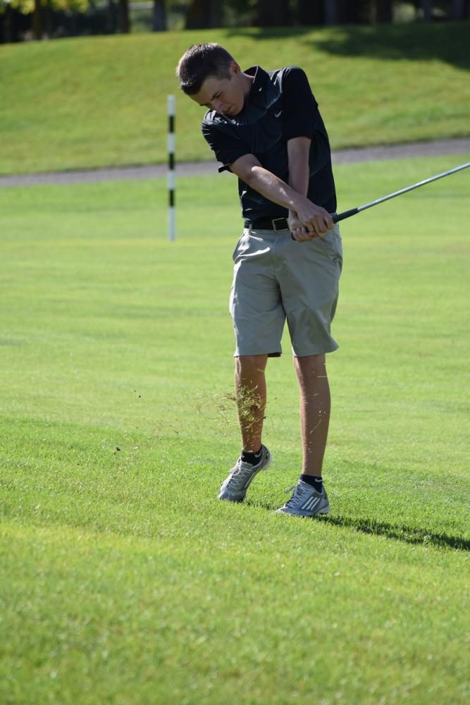 Casey Klover, junior, uses his pitching wedge to drive the ball closer to the green at a match on Aug. 23. The boys competed this day against Joliet Central.
