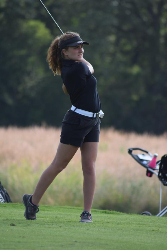 Caitlin Ritter, junior, tees off one of the holes at Heritage Bluffs on Aug. 24. The girls played against Plainfield North where they won by only one stroke.