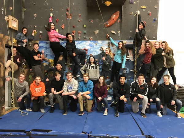 Members of the rock climbing club pose near the climbing wall in the small gym at Central Campus. 