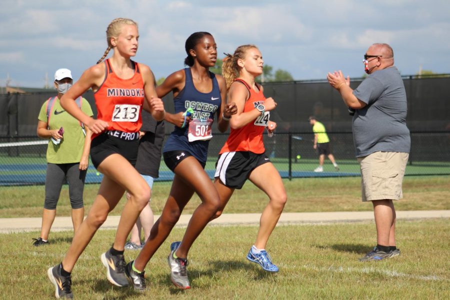 Freshman Cassie Fuhrman and sophomore Ella McColllom race against Oswego East on Aug. 29.