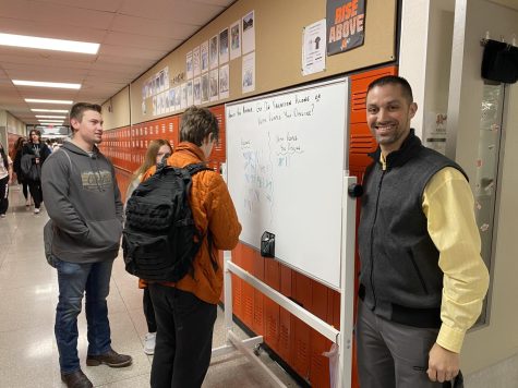 Mr. Matt Clark, math, is with his whiteboard, where he takes a daily poll on a “Would you rather” question.