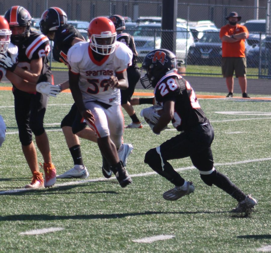 Freshman Jaxon Banner runs the ball against Romeoville on Sept. 8.  Minookas freshmen won 50-24.