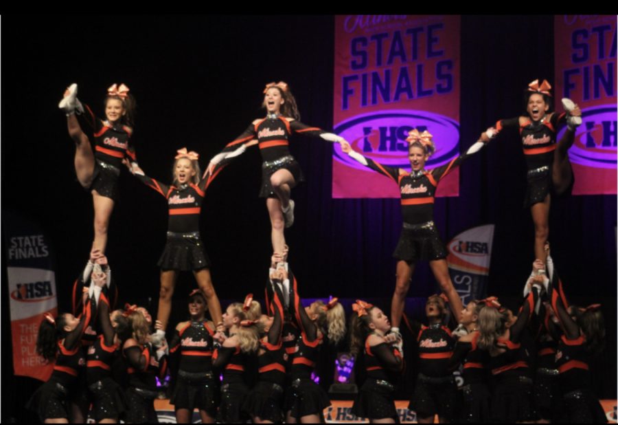 The+Minooka+varsity+cheer+teams+hits+the+last+structure+of+the+pyramid+at+state+on+Feb.+3.